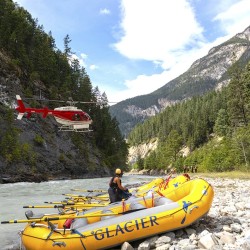 helicopter flying above Glacier Raft Company rafts by Kicking Horse River