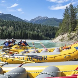 glacier raft company boats sitting beside kicking horse river