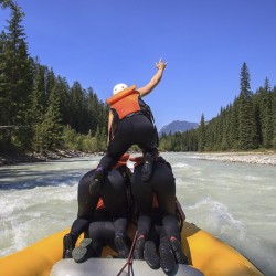 guests make a human pyramid in their raft on the kicking horse river