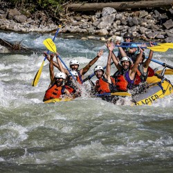 guests rafting kicking horse with big smiles and paddles up