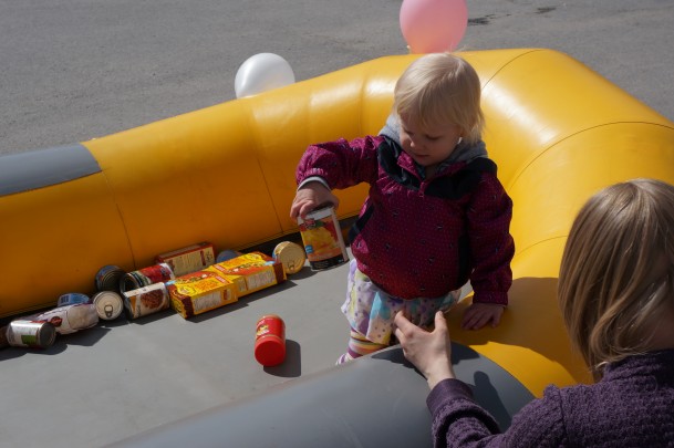 A little girl giving a food donation to our Fill a Raft Campaign