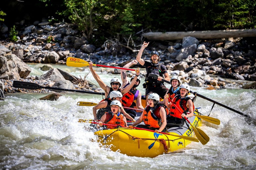 A group smiling in their raft while rafting on the Kicking Horse River