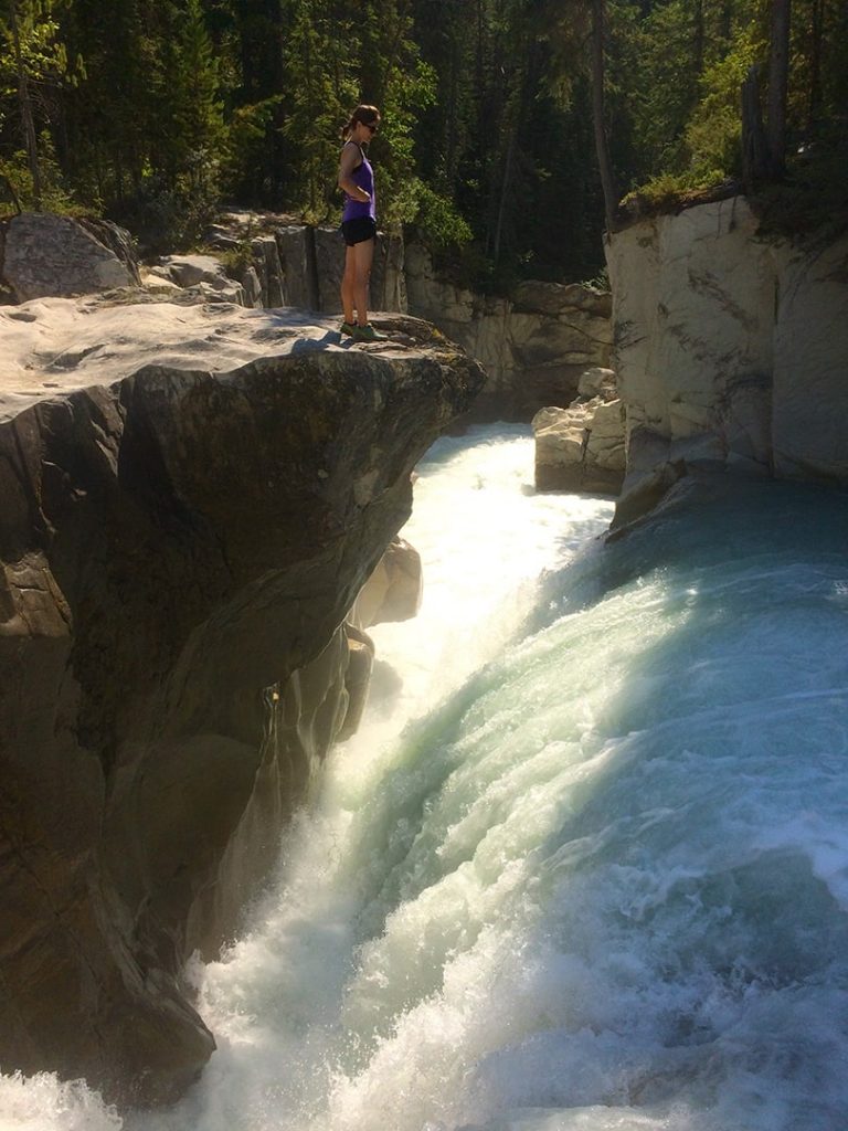 Girl by waterfall on the Thompson Falls hike