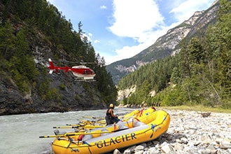 Helicopter flying into lower canyon of Kicking Horse River for heli rafting trip